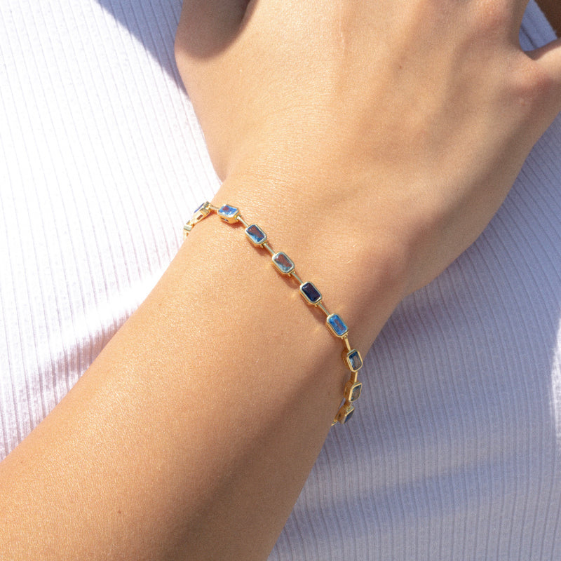 gold tennis bracelet with light blue gemstones