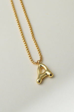 Gold necklace with a letter 'A' pendant on a light gray background