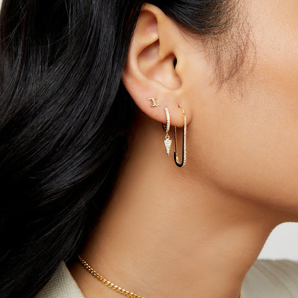 gold safety pin earrings on the model